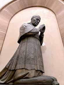 Archbishop Ettore Baranzini kneels in prayer
